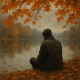 5 Bolnih, ali jasnih istina u životu koje prebrzo zaboravljamo | A melancholic yet insightful scene of a person reflecting by a quiet lake, surrounded by autumn leaves.